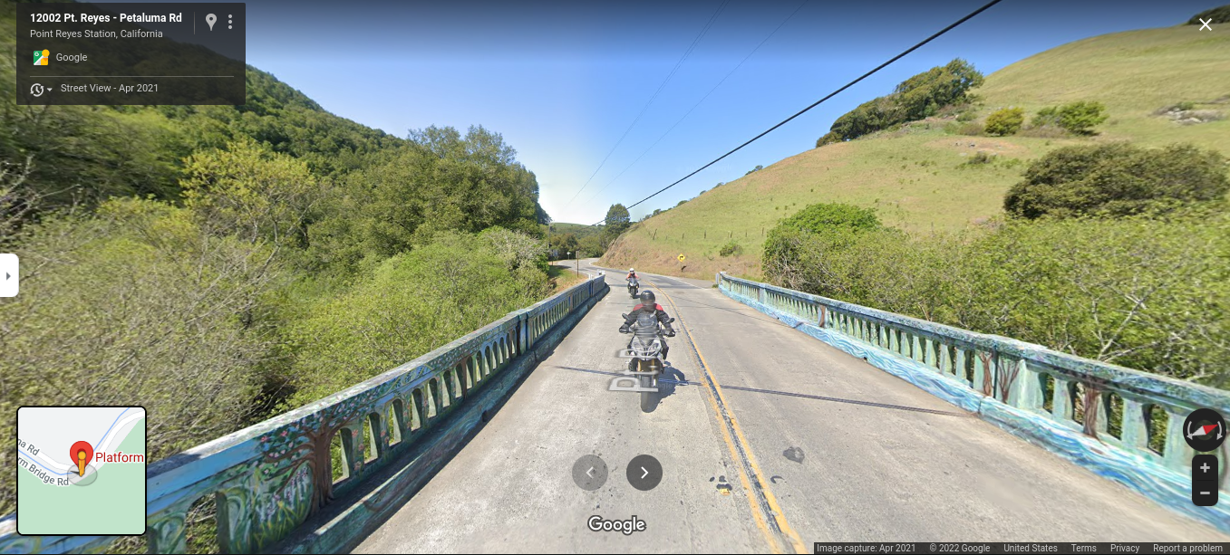 A couple of motorcycles traveling across Platform Bridge