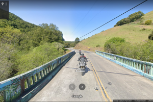 A couple of motorcycles traveling across Platform Bridge